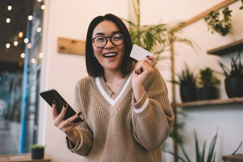 Girl with SmartvCard Digital business card using smartphone in cafe