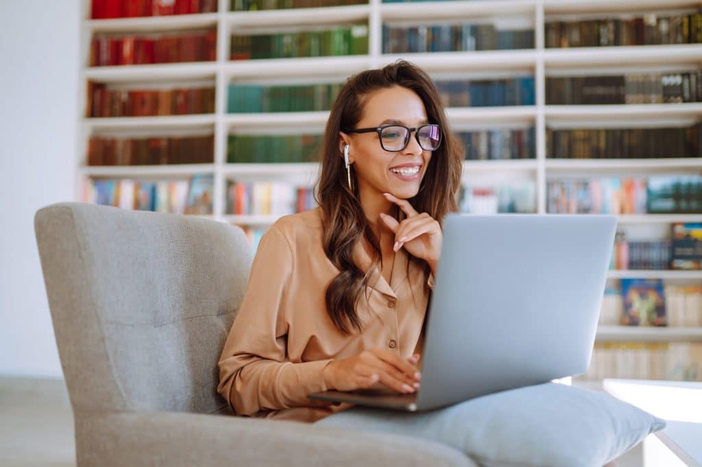 Portrait of happy young woman with laptop. Freelancer working on laptop. Business, online concept.