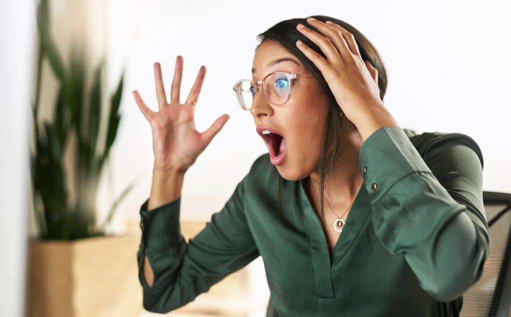 Shot of a young businesswoman looking at her PC screen in shock because of SEO Mistakes